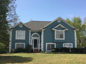 Completed residential roofing project with clean fascia and seamless gutters